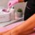 Professional esthetician preparing pink wax in a LYCON wax heater before a leg waxing treatment.