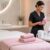 Beauty professional holding LYCON Pinkini Pre-Waxing Oil beside professional waxing products in a modern salon treatment room