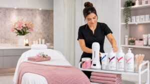 Salon owner organizing LYCON professional waxing products and equipment in a clean beauty treatment room